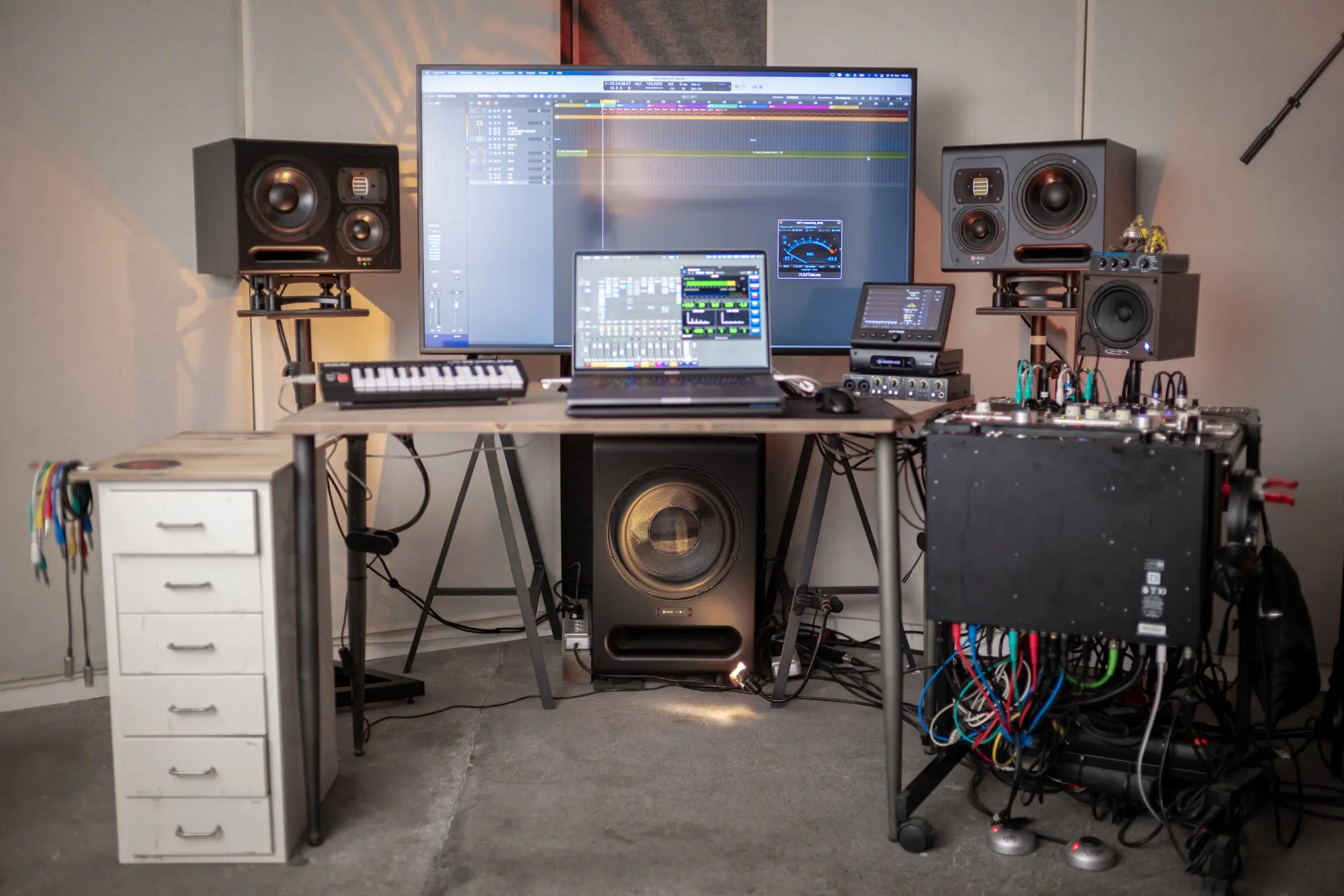 A desk setup with a subwoofer placed under the desk