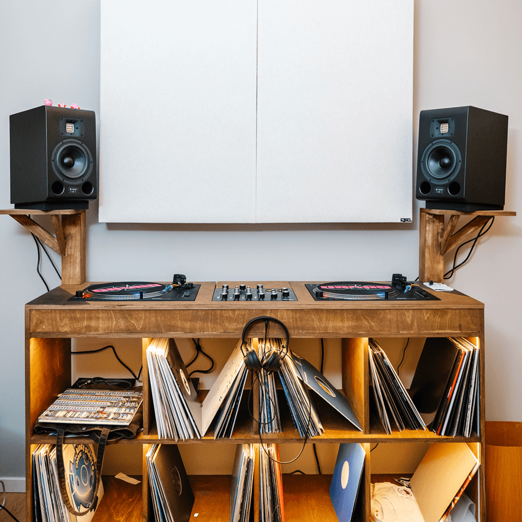TYPE 07 ACORE monitors with turntables, mixer, and vinyl records on a wooden shelf against a white wall.
